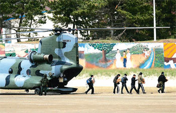 경기 평택시 해군 제2함대사령부에서 육군 치누크 헬기를 타고 온 천안함 실종자 가족 대표들과 합동 조사단원들이 14일 백령도 사곶비행장에 내리고 있다. 이들은 곧바로 해군 헬기 2대에 나눠 타고 천안함 인양작업 지휘본부인 독도함으로 향했다. 백령도=홍진환 기자