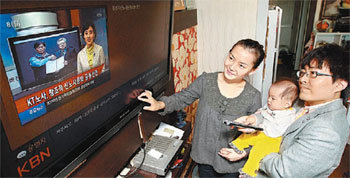 KT 직원 가족들이 자택 거실에서 인터넷TV(IPTV)를 통해 KT의 ‘집으로 찾아가는 사내방송’을 시청하고 있다. KT는 사내 소통 강화를 위해 16일 이 서비스를 시작했다. 사진 제공 KT