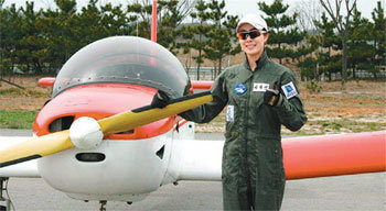 14일 경기 안산시 상록구 사동 임시비행장에서 영화배우 이화선 씨가 훈련용 경비행기를 배경으로 환하게 웃고 있다. 이 씨는 30일 이곳에서 개막하는 2010 경기국제항공전 홍보대사를 맡아 직접 경비행기를 조종할 예정이다. 안산=이성호 기자