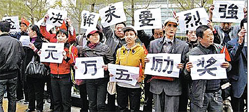 중국 공상은행 등 4개 국유은행 해직자들이 19일 베이징 중심지에서 시위를 벌이면서 ‘보상금 문제 해결을 강력히 요구한다’ ‘직원 한 명 해고하면 지점장이 5만 위안의 격려금을 받았다’는 내용의 피켓을 들고 있다. 사진 출처 홍콩 밍보 인터넷판
