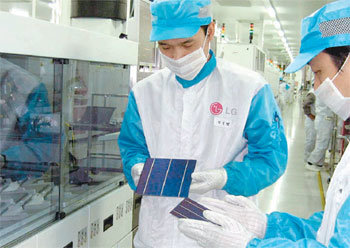 LG전자 구미 태양전지 생산라인에서 직원들이 태양전지 제품을 들고 결함이 없는지 살펴보고 있다. 사진 제공 LG전자