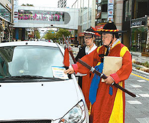울산 남구 삼산동 현대백화점 울산점 인근 디자인거리에서 포도대장 복장을 한 거리지킴이가 불법주차를 단속하고 있다. 사진 제공 울산 남구청