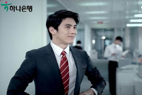 힘겹게 좁은 벽을 뚫고 나와 언제 그랬냐는 듯 말쑥한 차림으로 선배에게 인사하는 \'하나은행\'광고 속 장면은 고수의 평소 캐릭터를 잘 보여주는 컷이다. 사진제공 웰콤.