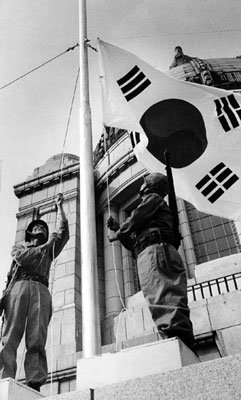 1990년 9월 28일 서울 종로구 세종로 국립중앙박물관(옛 중앙청) 국기게양대에서 박정모 예비역 대령(당시 66세·왼쪽)이 태극기를 게양하고 있다. 이날 박 대령은 1950년 9월 27일 해병대 소대장으로 서울탈환작전에 참여해 중앙청에 직접 태극기를 올리던 장면을 재현했다. 동아일보 자료 사진