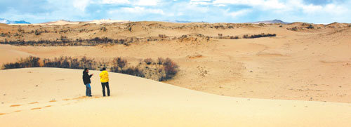 ▲ 몽골 울란바토르 서쪽 250km지점 초원지대에 형성된 모래사막 엘센타사르하이는 몽골 전역에서 진행 중인 사막의 실태를보여주고 있다. 5일 오후 이곳을 찾은 본보 김용석 기자(왼쪽)가모래사막을 살펴보고 있다.엘센타사르하이=박영대 기자