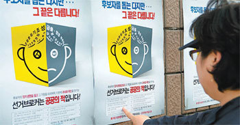 시민들이 ‘공공의 적’인 선거 브로커를 추방하자는 포스터를 유심히 살펴보고 있다. 사진 제공 경북도선거관리위원회