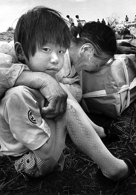 1980년 5월 29일경 광주 북구 망월동에서 진행된 5·18민주화운동 희생자 합동장례식에서 가족을 잃고 통곡하는 할머니에게 안긴 채 눈물을 흘리고 있는 어린아이. 전 동아일보 사진부 기자 김녕만 씨는 “이 사진이 5·18 당시 촬영한 1000여 장의 사진 중 가장아픈 기억으로 남아 있다”고 말했다. 사진 제공 김녕만 씨