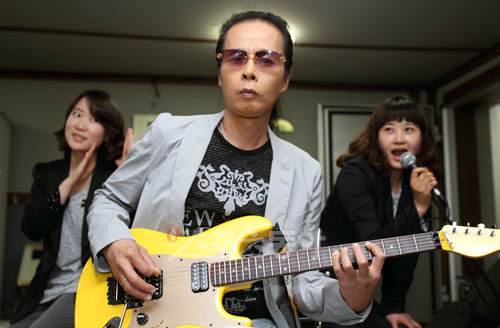 한국 최고의 록 기타리스트 김태원과 여기자들이 함께 포즈를 취했다. 그 어떤 예능 프로그램에서보다, 김태원은 기타를 들었을 때 진짜 폼이 나는 사람이다.