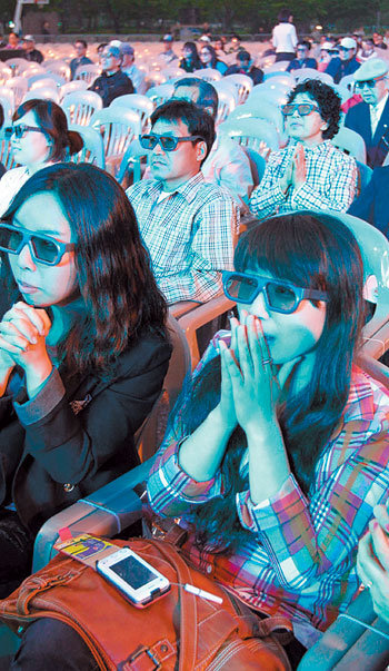 KBS가 19일 서울 여의도광장에서 연 대구국제육상경기대회 3D 중계 체험행사를 찾은 시민들이 3D 전용 안경을 쓰고 경기를 지켜보고 있다. 이번 중계는 지상파로서는 세계 최초의 3D 방송이다. 박영대 기자