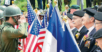 “그때 희생 잊지않겠습니다” 국기 전달  26일 경기 양평군 지평역 광장에서 열린 ‘지평리전투’ 기념 행사에서 육군 제7기동군단 장병들이 6·25전쟁 당시 이 지역에서 벌어졌던 치열한 전투 장면을 재연하고 있다(위 사진). ‘재연전투’가 끝난 뒤 육군 장병들은 이날 전투를 재연하면서 사용한 프랑스 국기를 프랑스 참전 용사들에게 전달했다(아래 사진).양평=박영대 기자