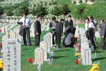 호국영령 묘비 정돈  4일 서울 동작구 동작동 국립서울현충원을 찾은 시민들이 호국영령의 묘비 주변을 정돈하며 참배하고 있다. 서울현충원 측은 “천안함 폭침사건 후 현충원 방문객이 지난해보다 늘었다”고 밝혔다. 이훈구 기자