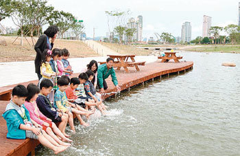 울산 태화강변에 조성된 태화강대공원이 착공 8년 만에 최근 개장했다. 대공원 중간으로 흐르는 실개천에서 어린이들이 발을 담그고 물놀이를 하고 있다. 사진 제공 울산시
