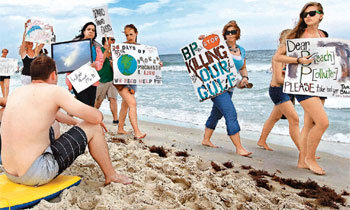 해변의 시위 멕시코 만 원유유출 사고를 낸 영국 석유회사 브리티시페트롤리엄(BP)을 비난하는 내용의 피켓을 든 시위자들이 6일 미국 플로리다 주 해변을 걷고 있다. 한 시위자는 BP를 ‘해변 오염자(Beach Polluter)’라고 표현했다. BP는 유출 원유의 회수작업을 벌이고 있지만 사고 지점에서 흘러나온 기름은 현재까지 반경 320km 해역까지 퍼져나간 것으로 밝혀졌다. 펜서콜라=AFP 연합뉴스