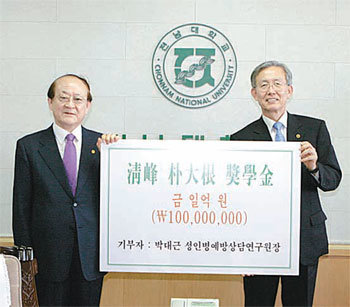 전남대 의대 졸업생 박대근 씨(왼쪽)가 8일 전남대를 방문해 김윤수 총장에게 장학금 1억 원을 전달했다. 사진 제공 전남대
