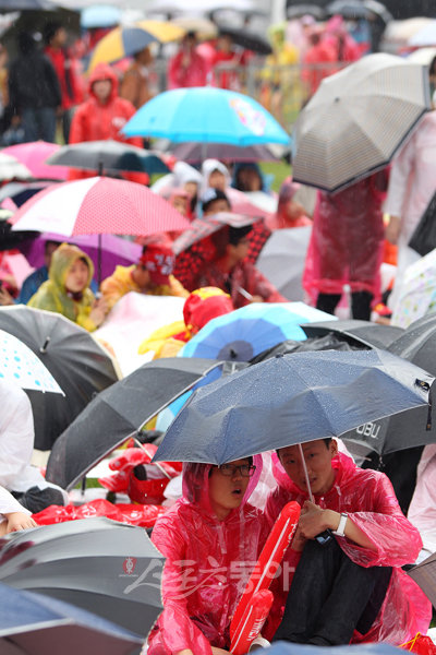 2010 남아공월드컵 그리스전이 열리는 12일 오후 서울시청 앞 광장에서 우비와 우산을 쓴 많은 시민들.