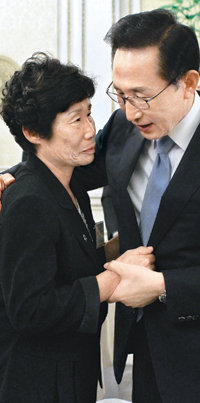 이명박 대통령이 14일 청와대에서 천안함 폭침사건으로 전사한 민평기 상사의 어머니 윤청자 씨를 위로하고 있다. 윤 씨는 자신이 받은 국민성금 가운데 1억 원을 방위성금으로 기탁했다. 사진 제공 청와대