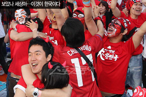 한국의 사상 첫 원정 월드컵 16강 진출이 확정되자 서울시청 앞 광장에 모여 응원하던 시민들이 서로 부둥켜안고 기쁨을 나누고 있다.