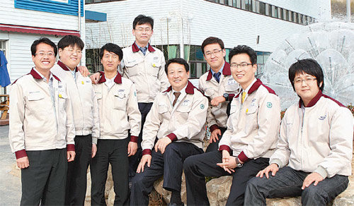 경북 상주시 나노 상주공장 내 중앙마당 분수대 앞에서 신동우 나노 사장(경상대 신소재공학부 교수·오른쪽에서 네 번째)이 임직원들과
 함께 포즈를 취하고 있다. 정영민 전략마케팅 팀장(오른쪽에서 두 번째)은 신 사장의 제자로 1999년부터 함께해 온 창업 
멤버이다. 사진 제공 나노