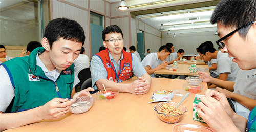 8일 오전 아침을 굶고 등교한 서울 중구 만리동 환일고교 학생들이 교내 식당에서 시리얼과 우유, 과일로 아침식사를 하고 있다. 옆에 있던 이기철 지도교사(왼쪽에서 두 번째)가 학생들에게 아침 챙겨먹기의 중요함에 대해 말하고 있다. 서울시와 자치구는 ‘굿모닝
아침밥 클럽’ 사업을 통해 조식 결식 학생에게 학교에서 균형 잡힌 아침 식사를 제공한다. 사진 제공 서울 중구청