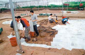 한양대 문화재연구소 발굴단원들이 경기 연천군 삼곶리유적을 매립하기에 앞서 경화 처리된 흙 표면을 한지로 덮고 있다. 사진 제공 한양대 문화재연구소