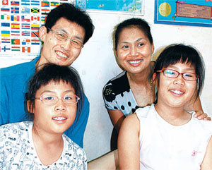 경남 진주시내 아파트에 살고 있는 바수칸 씨(뒷줄 오른쪽)와 남편 박승하 씨. 앞쪽은 쌍둥이 딸이다. 거실 벽면에는 딸들이 그린 그림과 세계지도 등이 붙어 있다. 진주=강정훈 기자