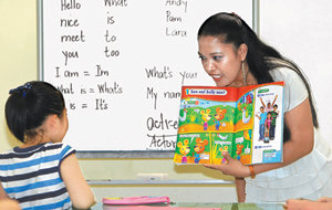 13일 경기 파주시 금촌동 중앙도서관에서 레지 엘시소 씨(오른쪽)가 한 어린이에게 교재를 보여주며 영어를 가르치고 있다. 엘시소씨가 영어 수업을 하게 된 것은 지역 실정에 맞는 다양한 희망근로사업이 마련된 덕분이다. 파주=박영대 기자