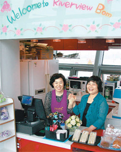서울시 여성가족재단이 구직여성과 여성 창업자를 연결해 주는 ‘1+1 프로젝트’에 참여해 플라워 카페에서 일하게 된 장성분 씨(왼쪽)가 카페 주인 이종애 씨와 손을 잡고 환하
게 웃고 있다. 조종엽 기자