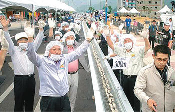 지난달 20일 전남 영광군 법성포 단오제 행사장에서 열린 생선 최장 거리 굽기 이벤트. 주민과 관광객이 영광굴비 1815마리를 301.2m 길이로 구워 신기록을 세운뒤 환호하고 있다. 사진 제공 영광군