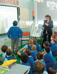 교사가 학생들에게 막대그래프 가로축과 세로축을 구성하는 방법을 설명하고 있다.