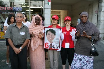 재보궐선거를 하루 앞둔 27일 서울 은평구 불광동의 골목에서 중앙선관위의 연수 프로그램에 참가한 외국인 선거 관계자들이 선거운동원들과 함께 포즈를 취하고 있다.