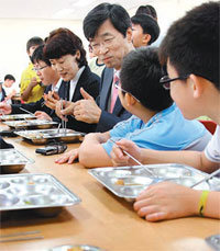 6월 21일 서울 강남구 세곡동 대왕초교에서 학생들과 급식을 먹고 있는 곽노현 서울시교육감(오른쪽에서 세 번째). 이 학교는 학생 56%가 무상급식 혜택을 받는 경기 성남시 거주 학생이고, 나머지는 저소득층이 아니면 급식비 지원을 못 받는 서울 거주 학생들이다. 동아일보 자료 사진