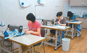 경북 상주시 중앙시장 빈 점포에 마련된 폐현수막 재활용센터에 서 3일 주민들이 시장바구니 등을 만들고 있다. 사진 제공 상주시