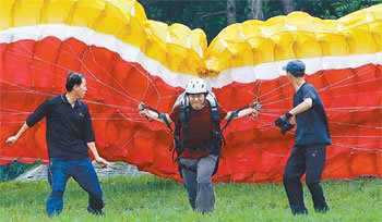 비행하려면 그 전에 날개를 세울 수 있어야 한다. 김성규 기자(가운데)가 춘천파일럿클럽의 양건모(왼쪽) 임상현 씨의 도움을 받으며 날개를 끌어 일으키려고 안간힘을 쓰고 있다. 춘천=원대연 기자