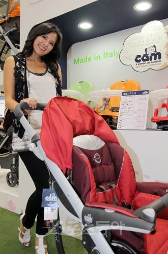 에바 포피엘이 자신이 모델로 나선 이탈리아 명품 유모차 ‘깜’을 천천히 밀며 미소 짓고 있다.