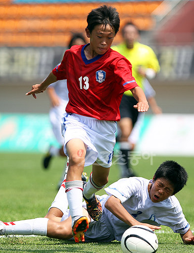 21일 경주시민운동장에서 열린 2010 경주 국제 유소년(U-12) 축구 페스티벌 결승전에서 한국 대표 화랑의 이승재(위)가 충무 수비수를 피해 드리블하고 있다. 경주 ｜ 임진환 기자 photolim@donga.com