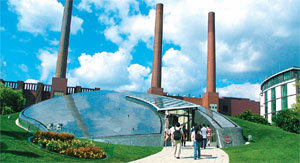 폴크스바겐 독일 볼프스부르크 공장의 차량 출고장이자 자동차 테마파크인 ‘아우토슈타트’. 원반처럼 생긴 유리 건물은 폴크스바겐그룹 산하 브랜드인 부가티 전시관 입구이며, 뒤로 볼프스부르크 공장 굴뚝이 보인다. 볼프스부르크=장강명 기자 tesomiom@donga.com