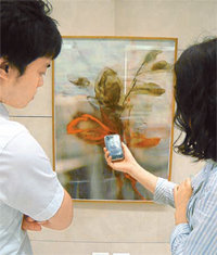 신세계백화점 본점에 전시 중인 미술작품을 감상하던 고객들이 스마트폰에 애플리케이션을 내려받아 작품 설명을 듣고 있다. 사진 제공 신세계갤러리