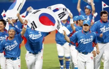 2008 베이징 올림픽에서 금메달을 따낸 한국야구대표팀 선수들이 태극기를 들고 기뻐하고 있다.