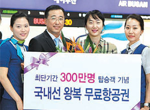 에어부산 김남진 김포지점장(왼쪽에서 두 번째)과 직원들이 김포공항에서 에어부산 300만 번째 탑승객인 조연정 씨와 기념촬영을 하고 있다.사진 제공 에어부산