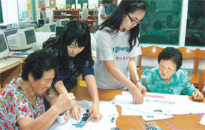 전남 순천시 상사면 용암마을 도서관에서 대학생들의 도움을 받아 티셔츠 문양에 염료를 칠하고 있는 마을 할머니들. 순천=강은지 기자 kej09@donga.com