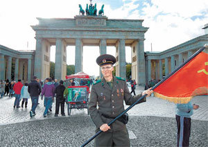 17일 독일 베를린 브란덴부르크 문 앞에서 60대 할아버지가 옛 소련군 제복 차림으로 소련 국기를 들고 서 있다.그는 브란덴부르크 문을 찾아온 관광객을 상대로 사진을 함께 찍어주는 대가로 돈을 받아 생계를 유지한다. 베를린=하종대 기자 orionha@donga.com