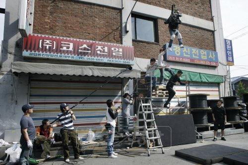 영화 ‘아저씨’ 중 건물 낙하 장면을 사실감있게 표현하기 위해 원빈과 촬영감독이 함께 건물에서 뛰어 내리고 있다.