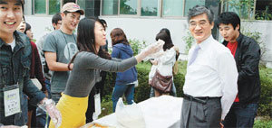 대구대 학생들이 30일 열린 학교 축제에서 교직원과 함께 만든 ‘행복 떡’을 홍덕률 총장(오른쪽)에게 건네고 있다. 사진 제공 대구대