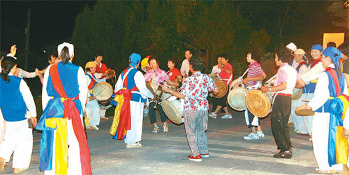 전남 영광군 영광읍 우평마을 주민들의 풍물굿놀이. 휘영청 밝은 달이 뜬 밤, 당산나무 아래에서 벌이는 풍물굿놀이는 수백 년간 이어져 온 당산제의 전통을 지속시키고 마을에 생기를 불어넣는다. 사진 제공 우도농악보존회