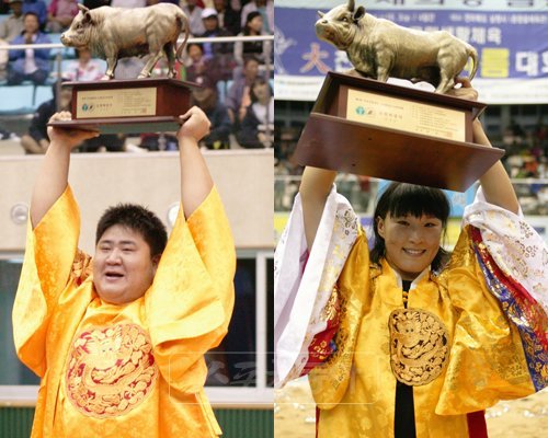 “내가 모래판 최강자”남녀 천하장사에 오른 김기영(왼쪽)과 임수정이 황소트로피를 들고 관중들의 환호에 답하고 있다.