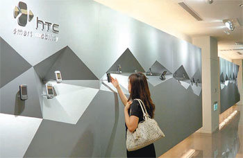 6일 대만 타이베이에 위치한 HTC 본사에서 한 소비자가 전시된 스마트폰을 만져보고 있다. HTC는 과감히 스마트폰 연구개발(R&D)에 투자해 지난해 스마트폰 시장에서 삼성, LG를 꺾고 세계 4위에 올랐다. 타이베이=김상운 기자 sukim@donga.com