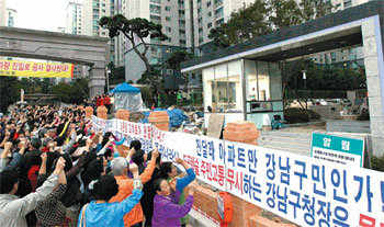 8일 서울 강남구 도곡동 도곡렉슬아파트 후문에서 입주민들이 시위를 하고 있다. 입주민들은 도로 앞에 재건축 중인 아파트가 도로를 내는 것에 항의해 벽돌로 담을 쌓아 놓았다. 김재명 기자 base@donga.com