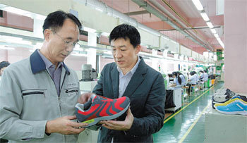부산 신발 제조업체인 보림산업의 최석열 상무(왼쪽)와 코오롱 헤드 브랜드 한승범 신발기획팀장이 신제품에 대해 의견을 교환하고 있다. 최근 첨단화와 레저화 바람이 불면서 기술 경쟁력을 갖춘 부산 지역 신발 산업이 호조를 보이고 있다. 부산=주성원 기자 swon@donga.com