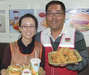 신춘식 씨(오른쪽)와 아내 이미선 씨가 판매하는 음식을 들고 포즈를 취하고 있다.