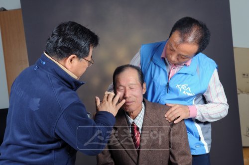한국마사회의 KRA-엔젤스 봉사단의 회원들이 최근 서해 연평도 노인들을 위한 봉사활동을 펼쳤다. 한 노인의 영정사진 촬영에 앞서 봉사단 회원들이 가벼운 메이크업을 해주고 있다